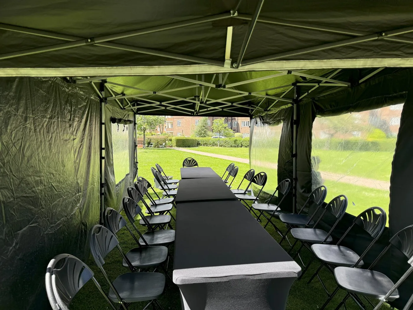 Long seated dining set up inside joined gazebos